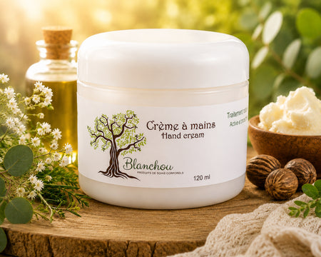 Crème à mains artisanale fabriquée à Cowansville par La Savonnerie Blanchou, présentée dans un pot de 120 ml et dans un décor naturel lumineux avec huiles végétales et végétation fraîche.