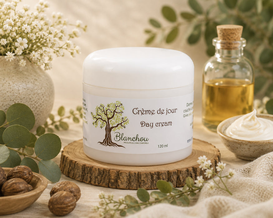 crème de jour artisanale fabriquée à Cowansville par La Savonnerie Blanchou, présentée dans un pot de 120 ml et dans un décor naturel lumineux avec huiles végétales et végétation fraîche.