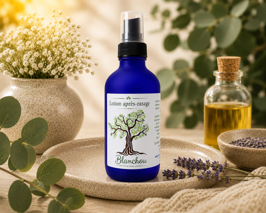 Lotion après-rasage naturelle fabriquée au Québec par La Savonnerie Blanchou, présentée dans une bouteille en verre bleu avec vaporisateur, entourée de lavande et d'huiles végétales dans un décor inspiré des soins corporels naturels.