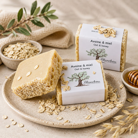 Savon artisanal avoine et miel de La Savonnerie Blanchou présenté avec flocons d’avoine et miel dans une ambiance naturelle chaleureuse
