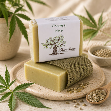 Savon artisanal au chanvre de La Savonnerie Blanchou présenté dans une ambiance naturelle avec feuilles et graines de chanvre