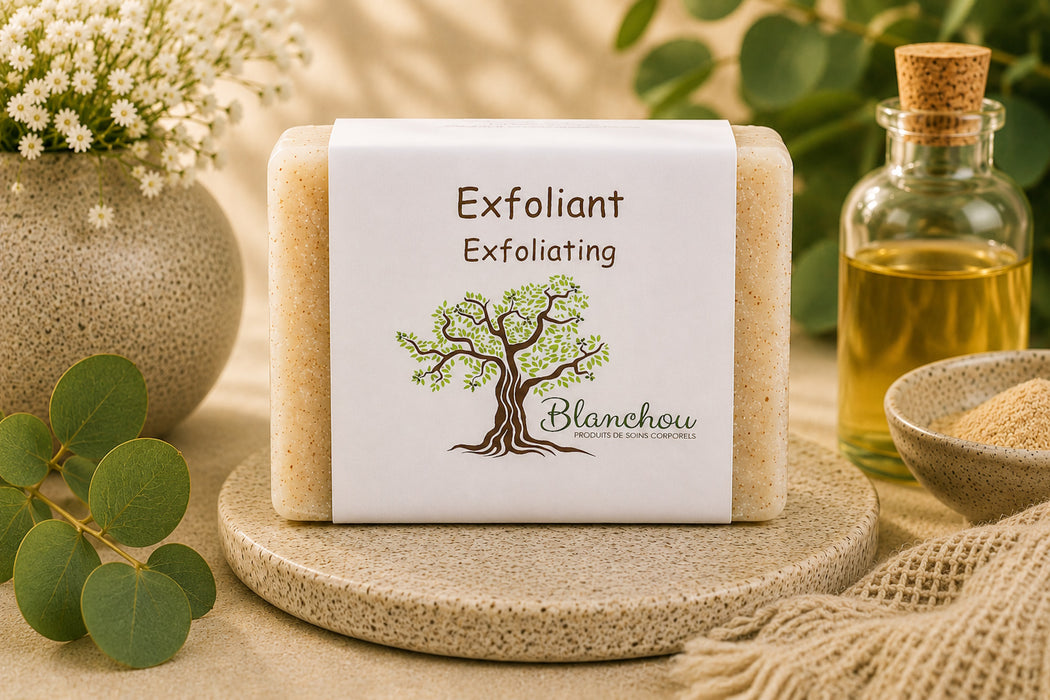 Savon exfoliant artisanal naturel La Savonnerie Blanchou présenté sur une table de bois avec huiles naturelles et feuillage au soleil