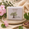 Savon artisanal au géranium de La Savonnerie Blanchou présenté dans une ambiance naturelle avec fleurs de géranium et feuillage apaisant