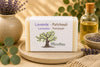 Savon artisanal lavande et patchouli de La Savonnerie Blanchou présenté dans une ambiance naturelle avec fleurs de lavande et huiles végétales
