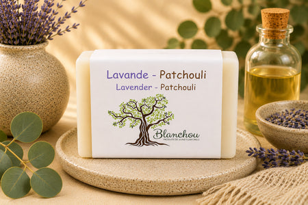 Savon artisanal lavande et patchouli de La Savonnerie Blanchou présenté dans une ambiance naturelle avec fleurs de lavande et huiles végétales