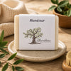 Savon Monsieur artisanal de La Savonnerie Blanchou présenté dans une ambiance naturelle élégante avec feuillage et lumière chaleureuse