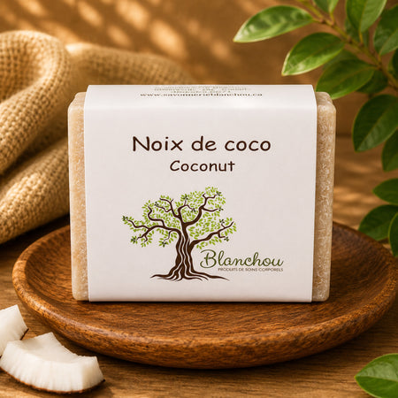 Savon artisanal à la noix de coco de La Savonnerie Blanchou présenté avec morceaux de noix de coco dans une ambiance naturelle chaleureuse
